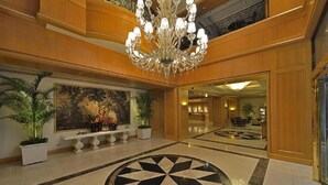 A spacious lobby with a large chandelier, a central floral arrangement, and a geometric floor design. - The Sherwood Taipei (Taipei)