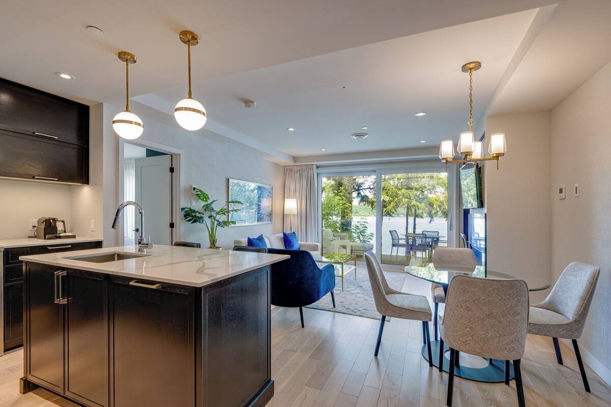 A modern kitchen with a central island, stainless steel appliances, and pendant lighting.