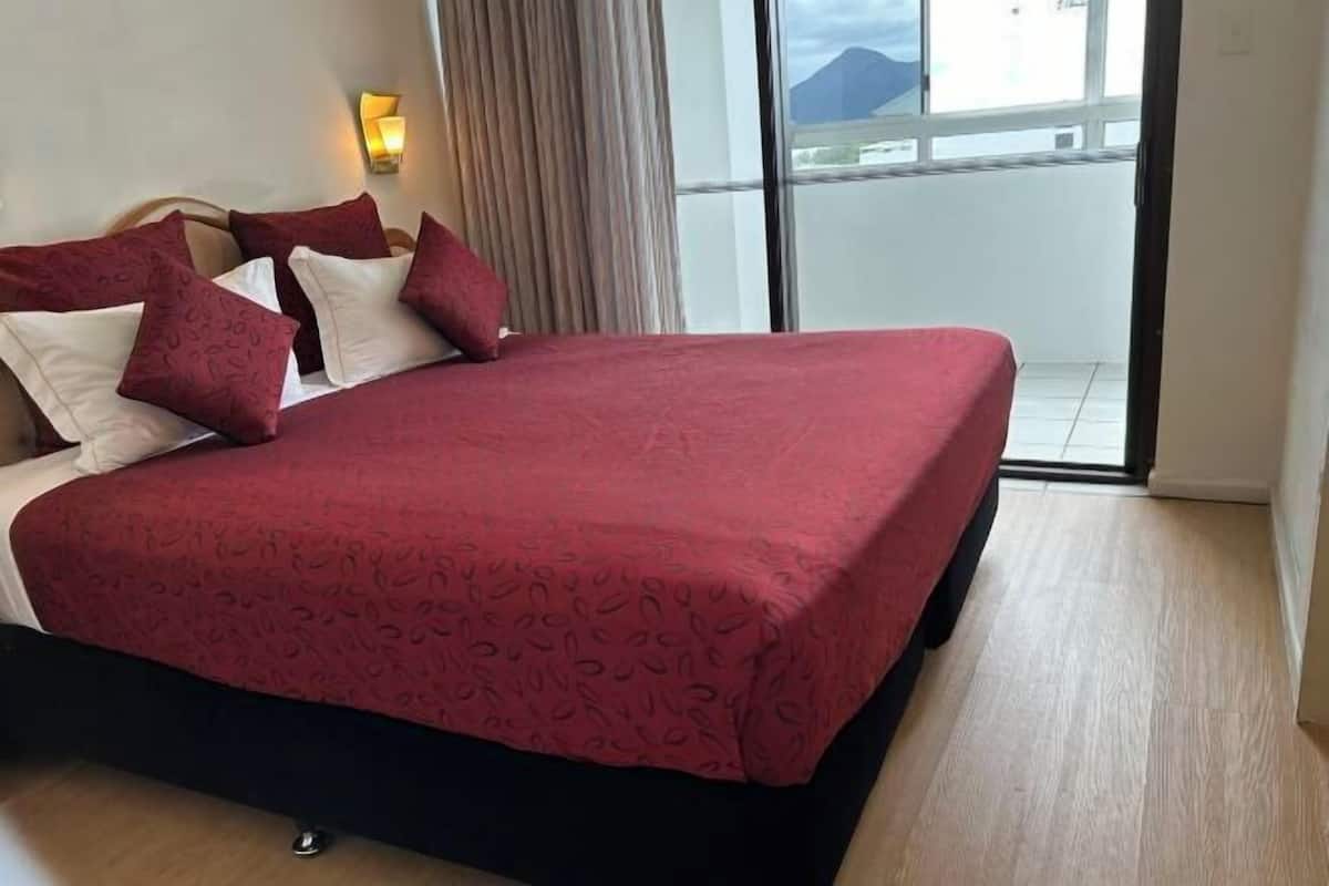 Desk, laptop workspace, iron/ironing board, bed sheets