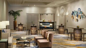 A hotel lobby with a seating area, a large potted plant, a decorative wall, and a vintage car display. - The Westin San Antonio North (San Antonio)