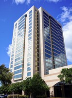 A tall, modern building with a symmetrical facade, large windows, and a flat roof.