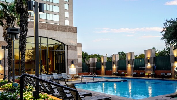 A hotel pool area with lounge chairs and a building with large windows in the background. - The Westin San Antonio North (San Antonio)