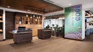 A reception area with wooden reception desks, a large welcome sign, and a modern interior design. - Four Points by Sheraton Fort Lauderdale Airport/Cruise Port (Fort Lauderdale)