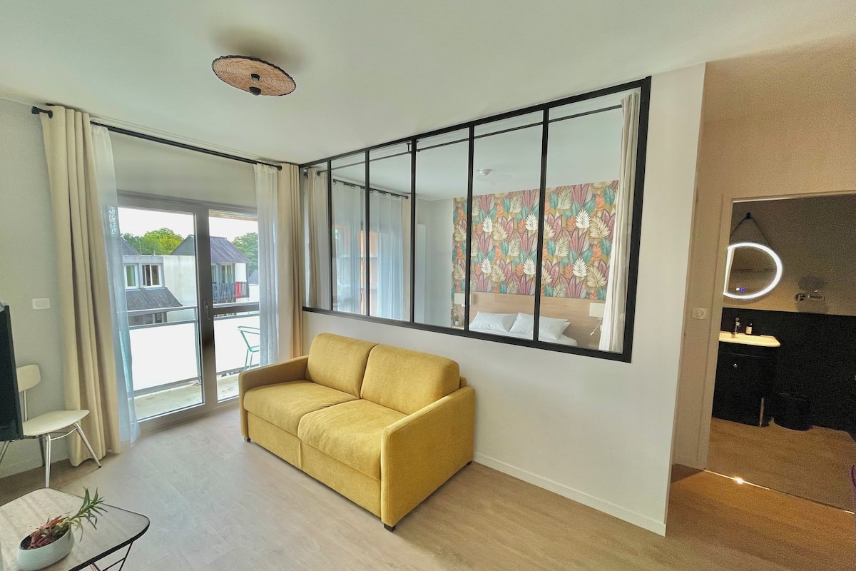 Ein modernes Wohnzimmer mit einem gelben Sofa, einem großen Fenster und einer Wand mit Spiegeln.