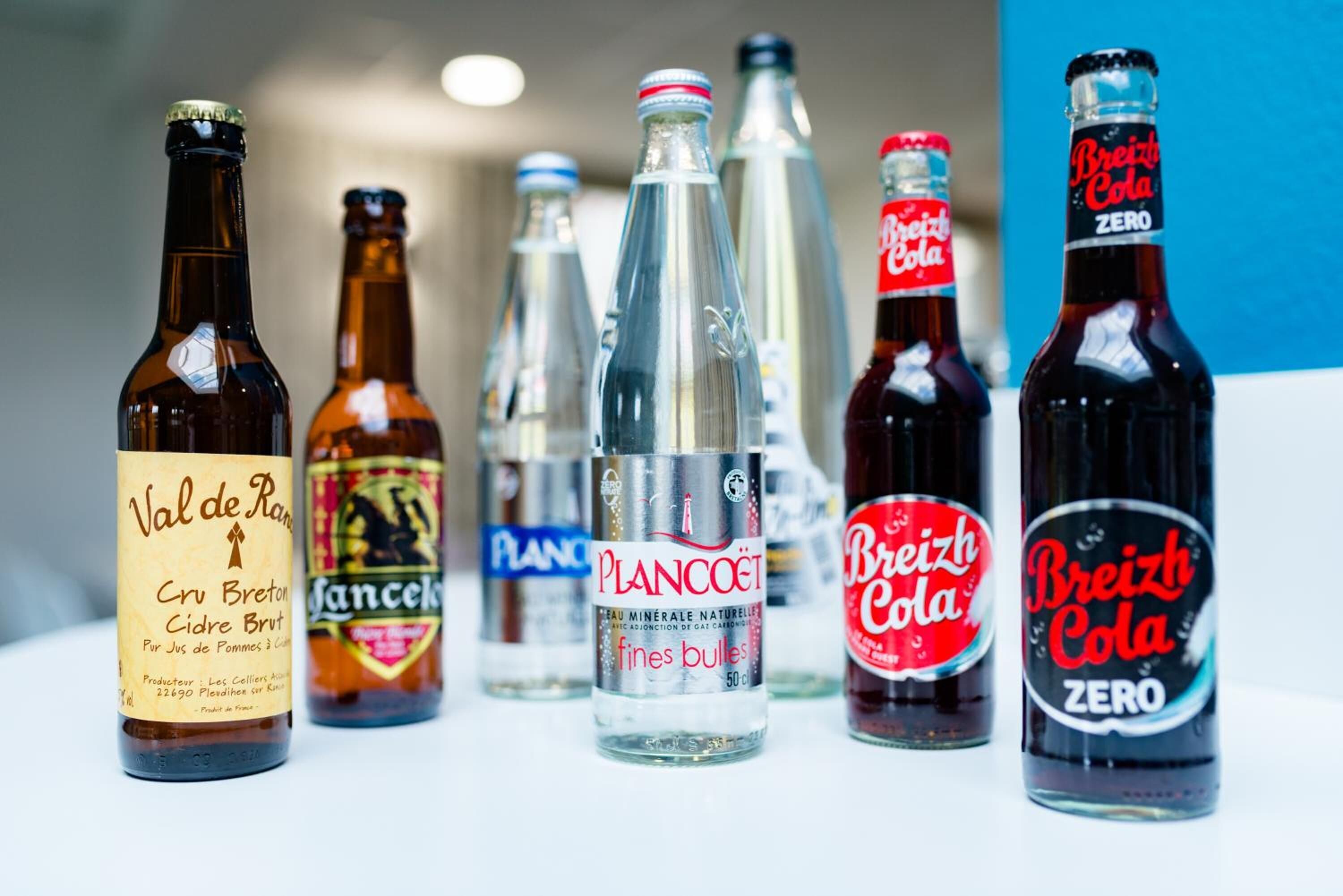A variety of beverage bottles including Val de Rans, Plancoet, and Breizh Cola Zero.