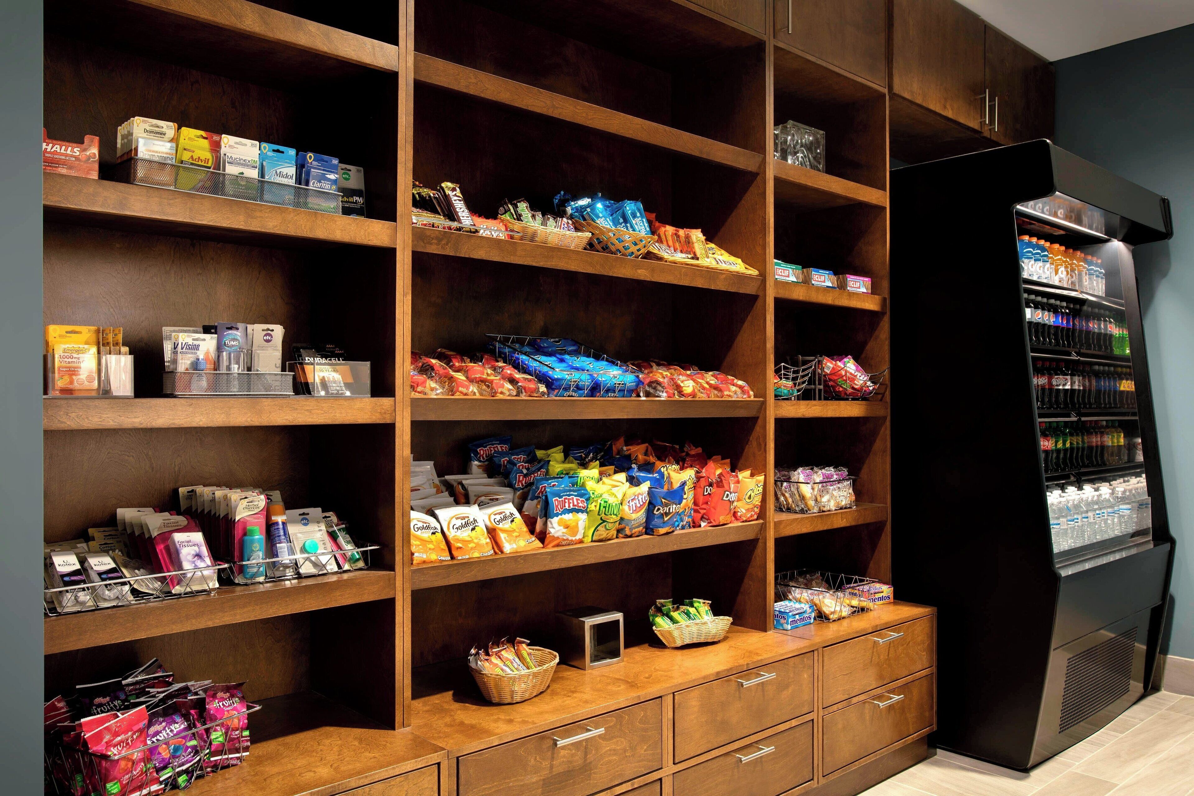 A well-organized snack and beverage area with multiple shelves stocked with various snacks, drinks, and packaged goods.
