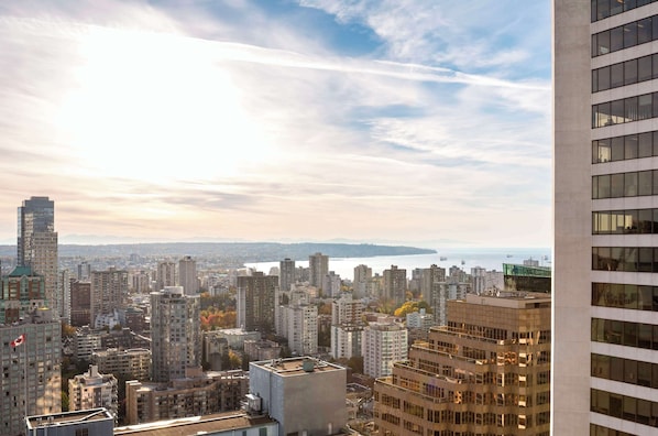 Un paysage urbain avec de hauts immeubles, une promenade au bord de l’eau et un ciel dégagé.