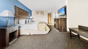 Ein Hotelzimmer mit einem Bett, Nachttischen, einem Fernseher und einem gemusterten Teppich.