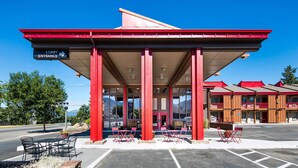 Un bâtiment à la façade rouge et doté d’un espace d’entrée abrité.
