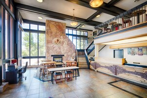 A spacious lobby with a stone fireplace, a staircase, and a reception desk.