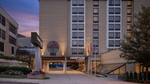 A Courtyard by Marriott hotel with a modern design, featuring a prominent entrance, flag display, and landscaped surroundings.