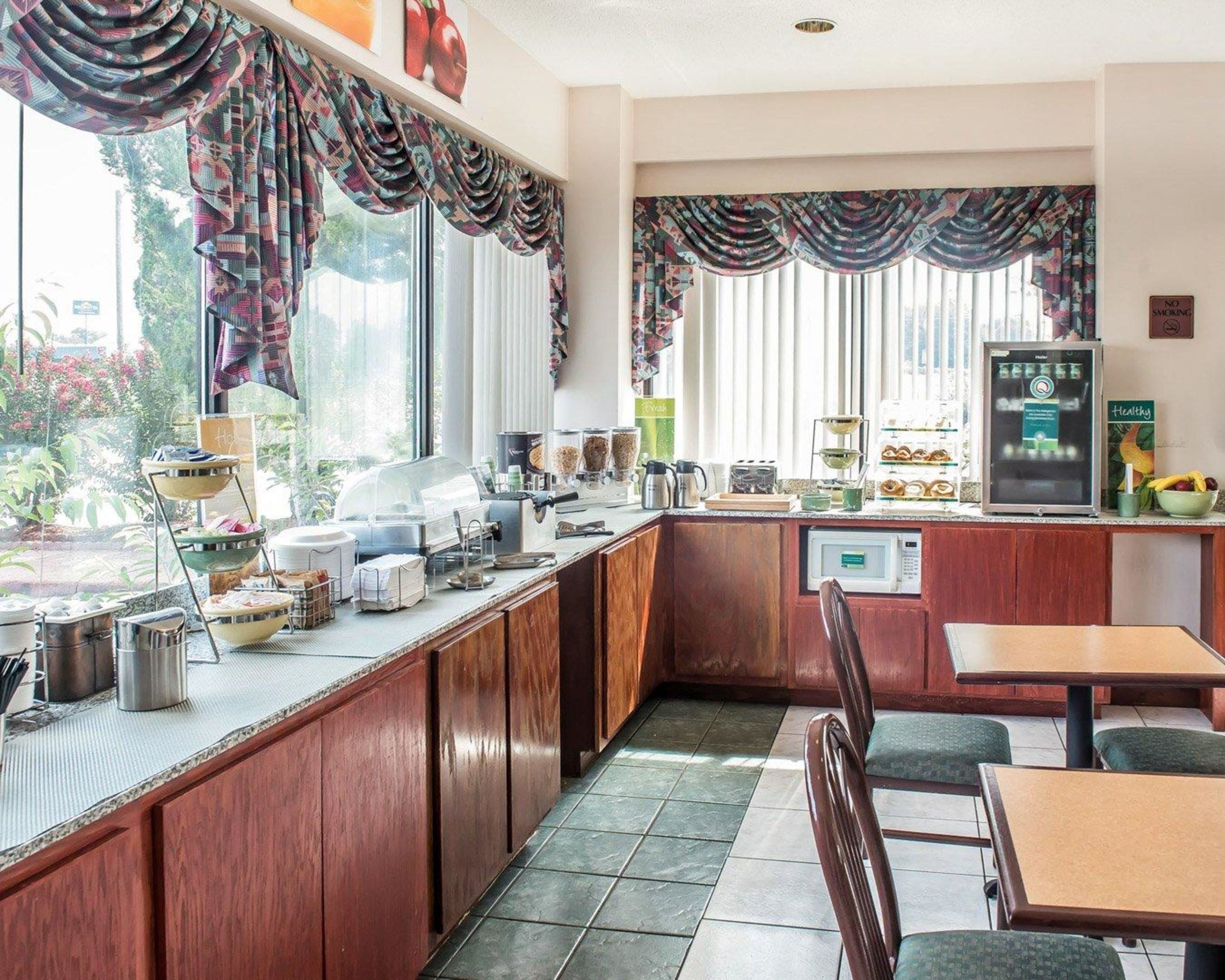 A kitchen with a counter, microwave, and seating area.