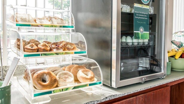 A breakfast display with pastries and a refrigerator containing beverages. - Quality Inn Marianna South (Marianna)