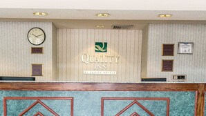 A reception area with a clock, a Quality Inn logo, and several plaques on the wall. - Quality Inn Marianna South (Marianna)