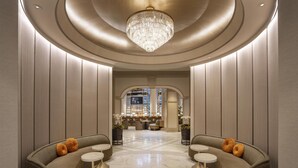 A luxurious lobby with a grand chandelier, plush seating, and a view of the bar area. - Grand Hyatt Atlanta in Buckhead (Atlanta)