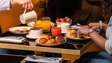 A breakfast setting with various food items and drinks on a table.