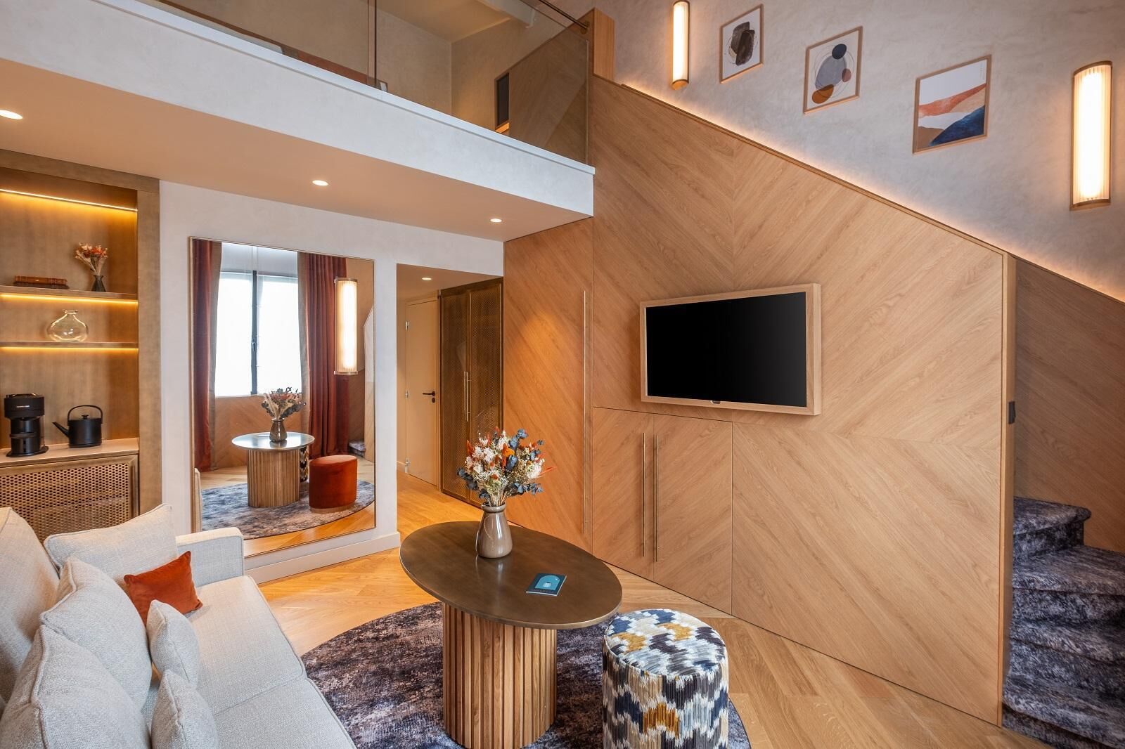 Een moderne woonkamer met een bank, salontafel en een wandmontage flatscreen televisie.