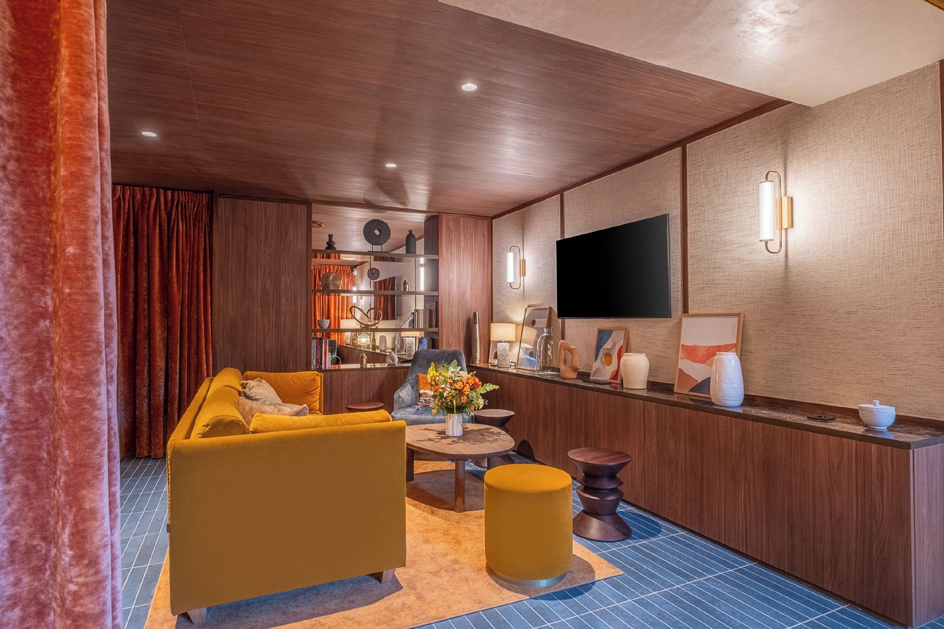 Un salon moderne avec un canapé, une table basse et un téléviseur.