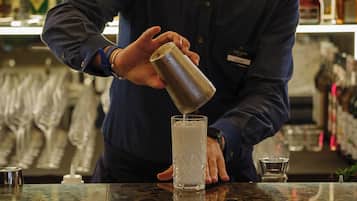 Un barman sirviendo una bebida en un vaso.