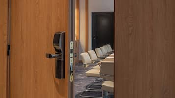 A conference room with a long table and several chairs, a door labeled "CHARTRONGS," and a carpeted floor.