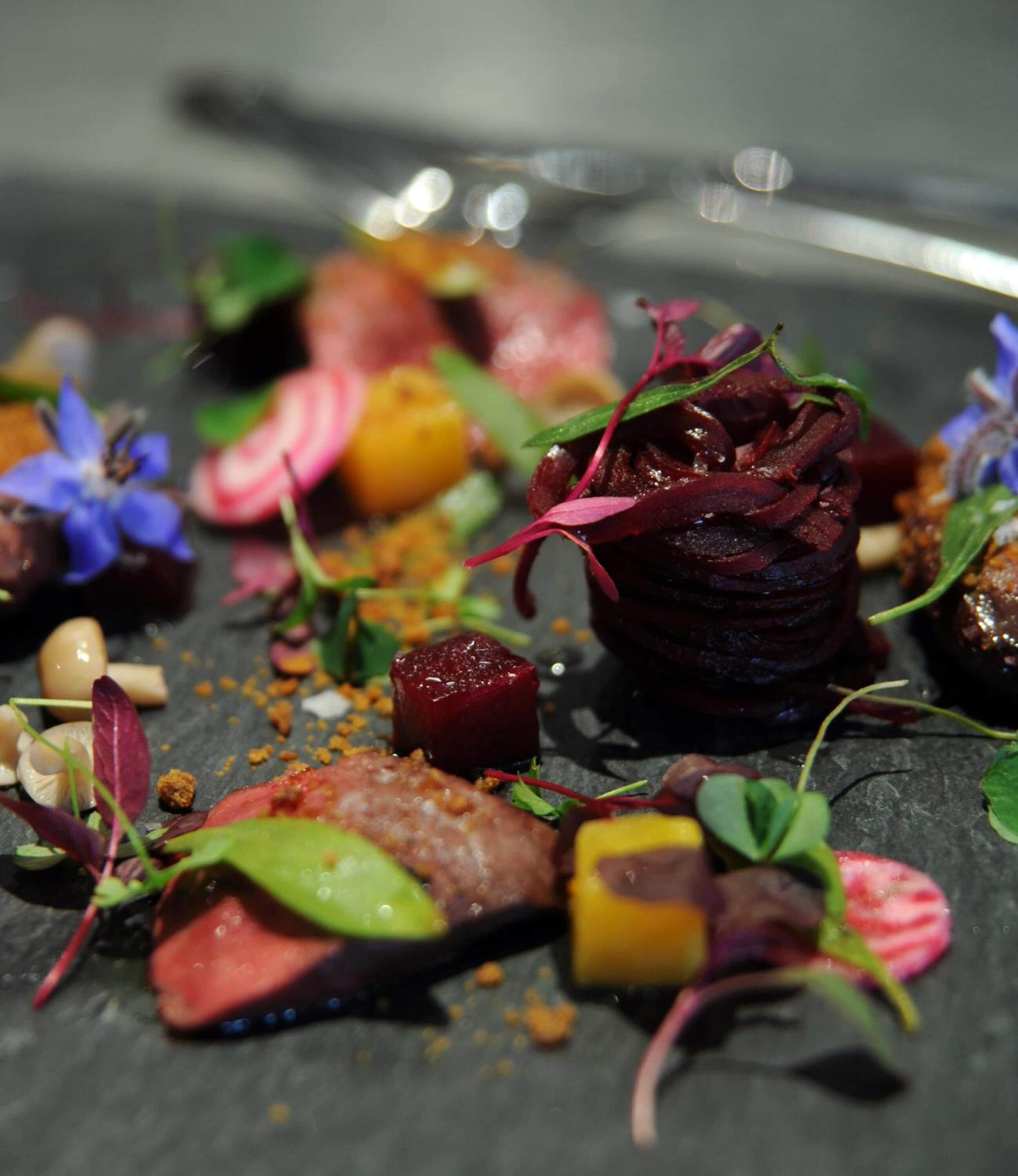 A variety of colorful food items arranged on a dark slate plate.