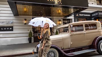A vintage car parked in front of a building with a sign reading "Kixby".