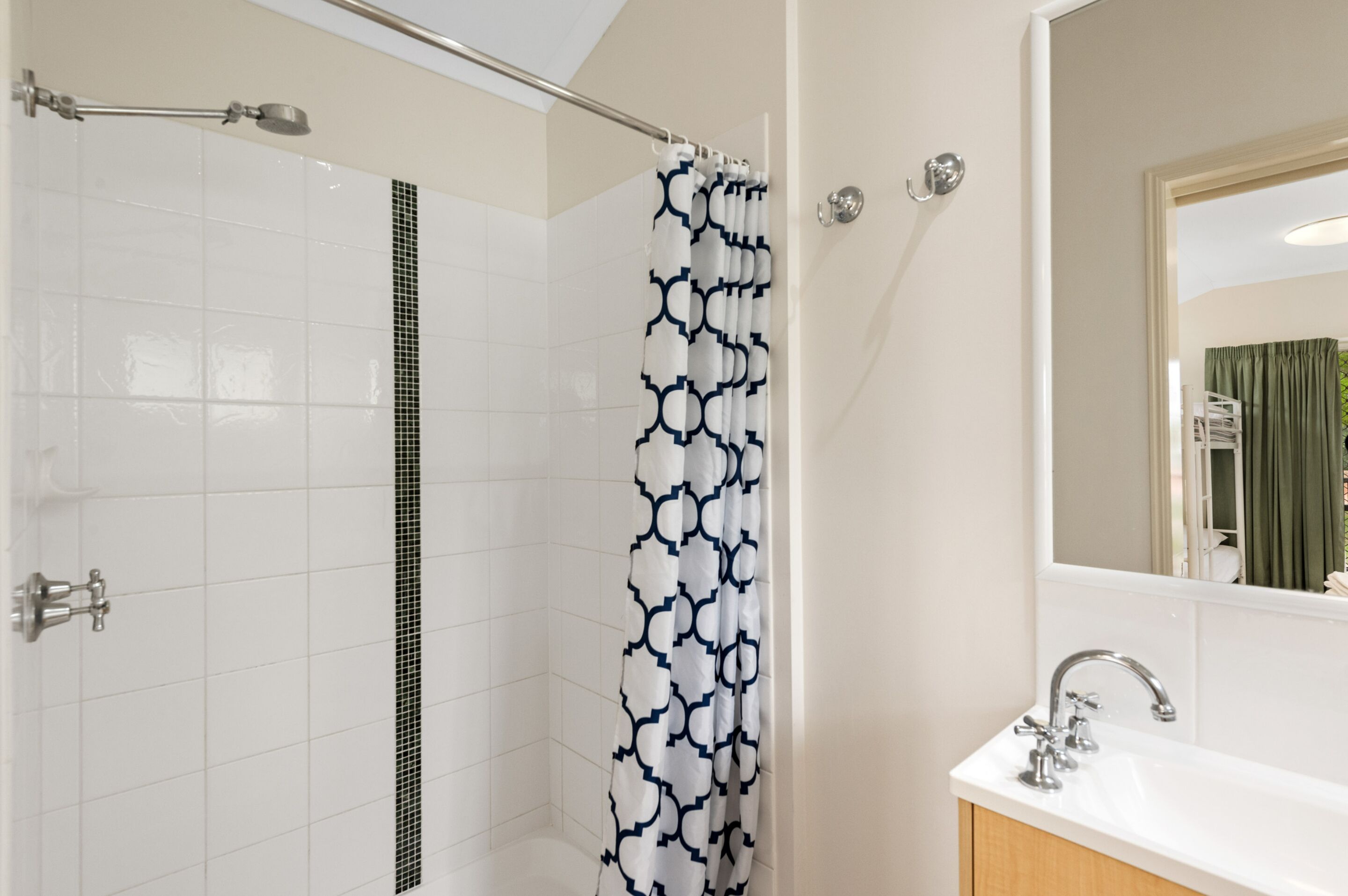 A bathroom with a shower, a sink, and a mirror.