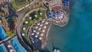 An aerial view of a resort with multiple swimming pools, sun umbrellas, and a beach area. - Elounda Bay Palace, a Member of the Leading Hotels of the World (Agios Nikolaos)