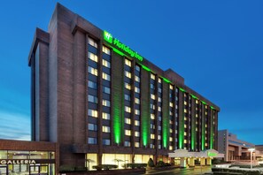 A multi-story building with a prominent green sign indicating a Holiday Inn.