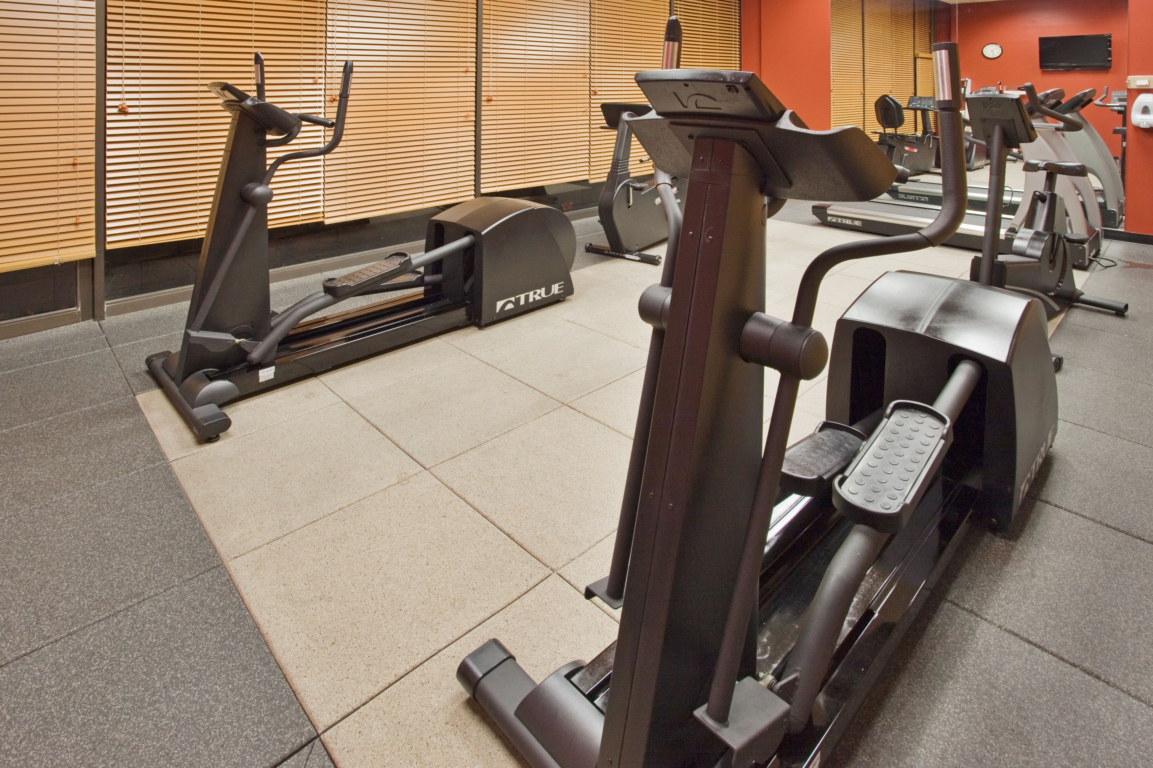 A gym with various exercise equipment, including treadmills and stationary bikes.
