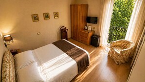 A hotel room with a bed, a wardrobe, a television, a small table, and a chair. - NSM Hotel Cicolella (Foggia)
