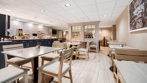 A modern restaurant with a clean, minimalist interior, featuring a mix of wooden and metal furniture, a tiled floor, and a bright, well-lit ambiance.
