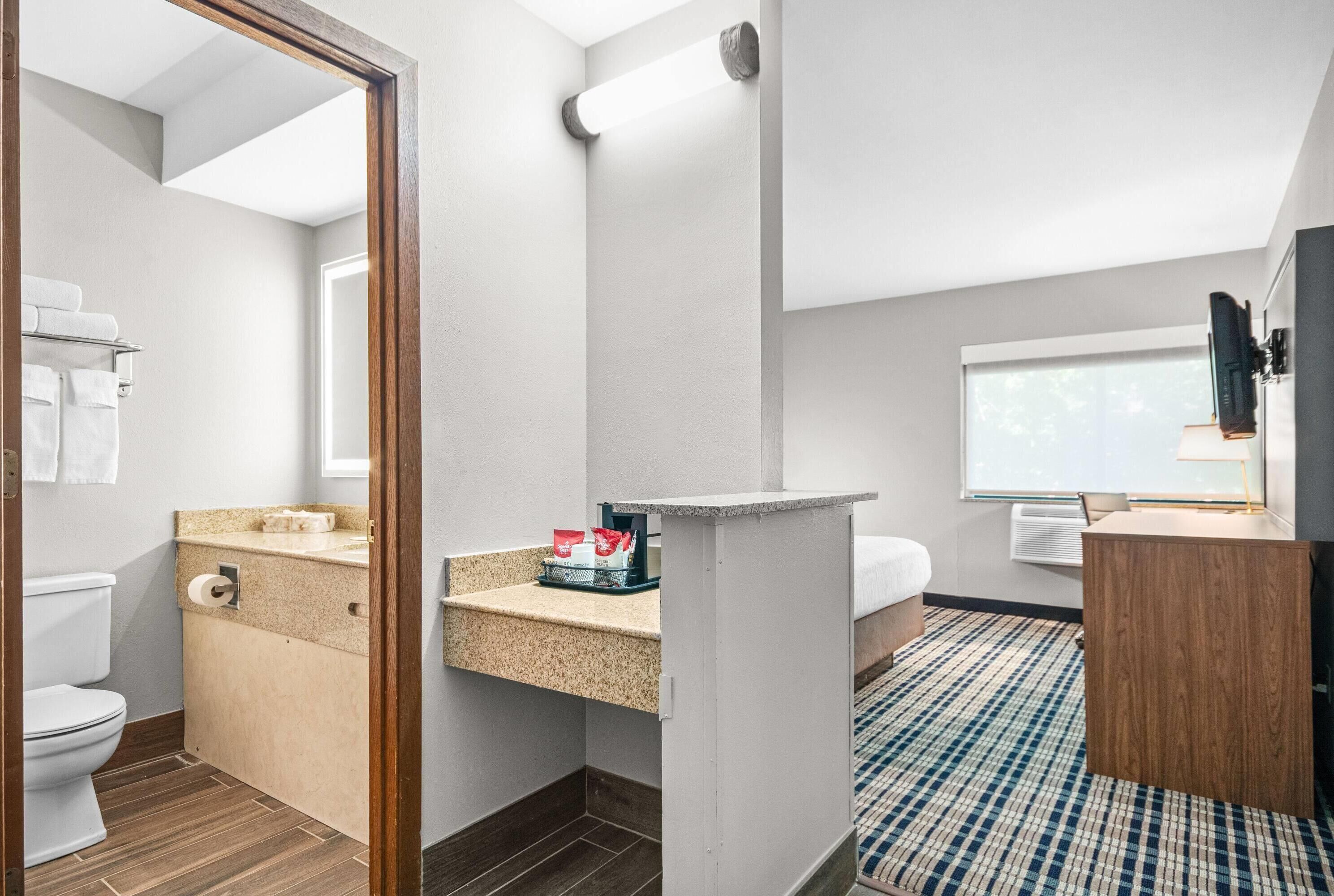 A modern bathroom with a toilet, sink, and mirror.