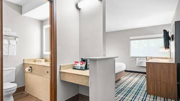 A modern bathroom with a toilet, sink, and mirror.
