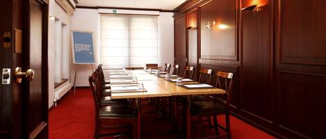 A conference room with a long table, chairs, and a whiteboard.