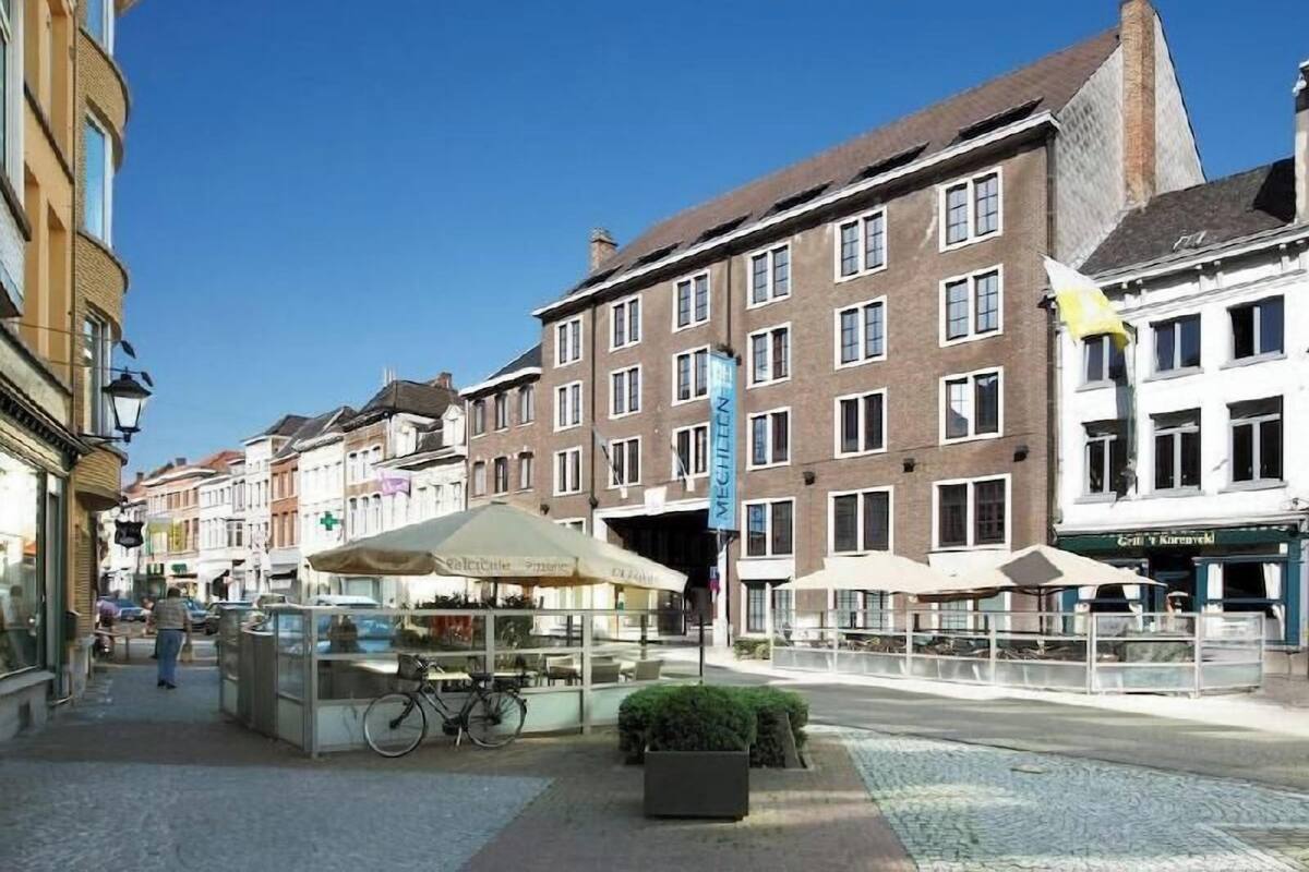 A street with buildings, a bicycle, and a kiosk.