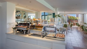 A buffet area with various food stations, including a grill, salad bar, and fruit display. - Hotel Palladium Palace (Rome)