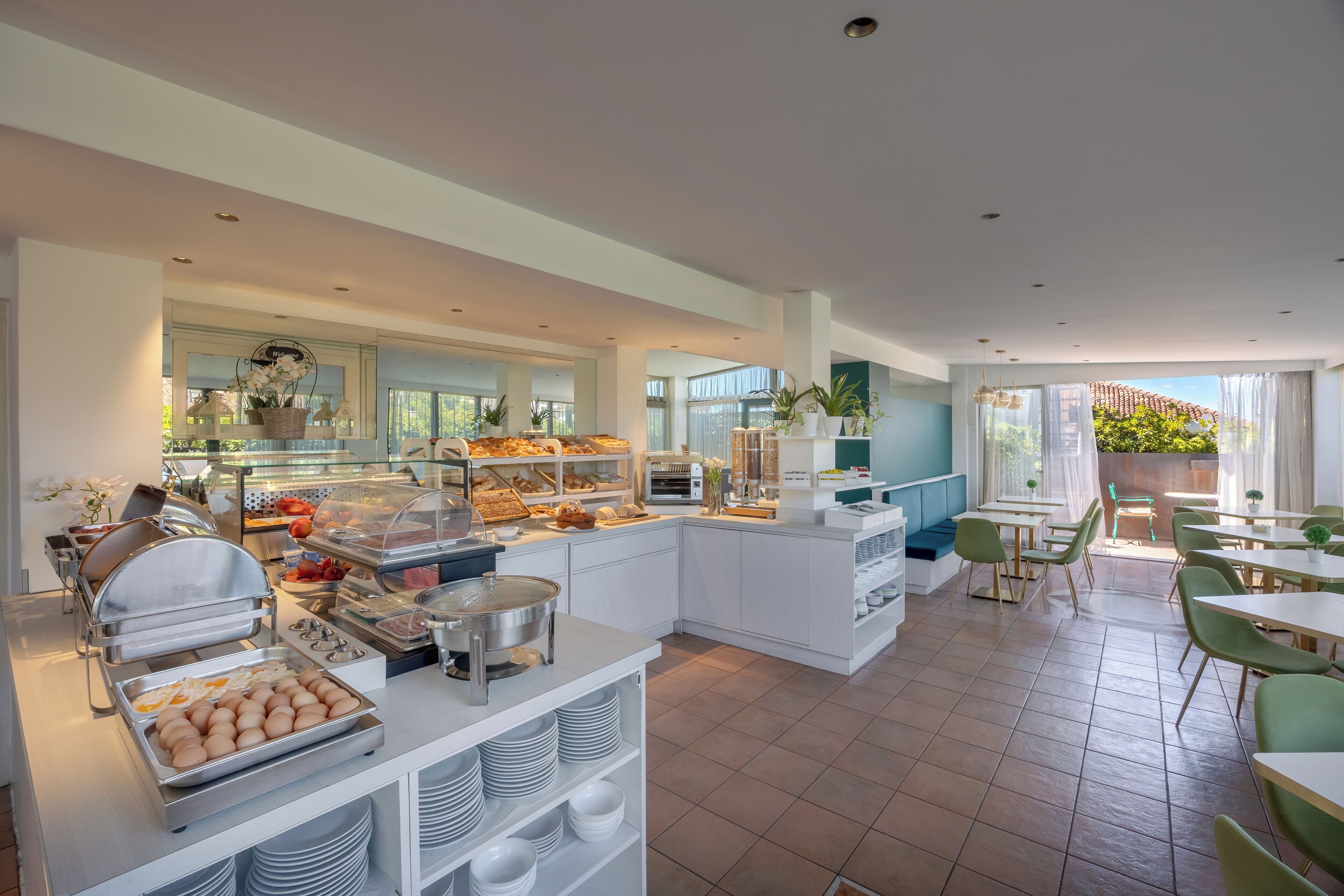 Ein modernes Frühstücksbereich mit Buffettheken, Sitzgelegenheiten und großen Fenstern.