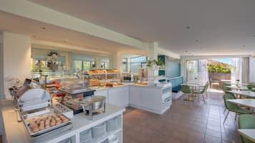 Ein modernes Frühstücksbereich mit Buffettheken, Sitzgelegenheiten und großen Fenstern.