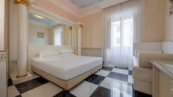 Ein Hotelzimmer mit Schachbrettmuster-Boden, einem Bett, einer Sitzecke und einem großen Spiegel.