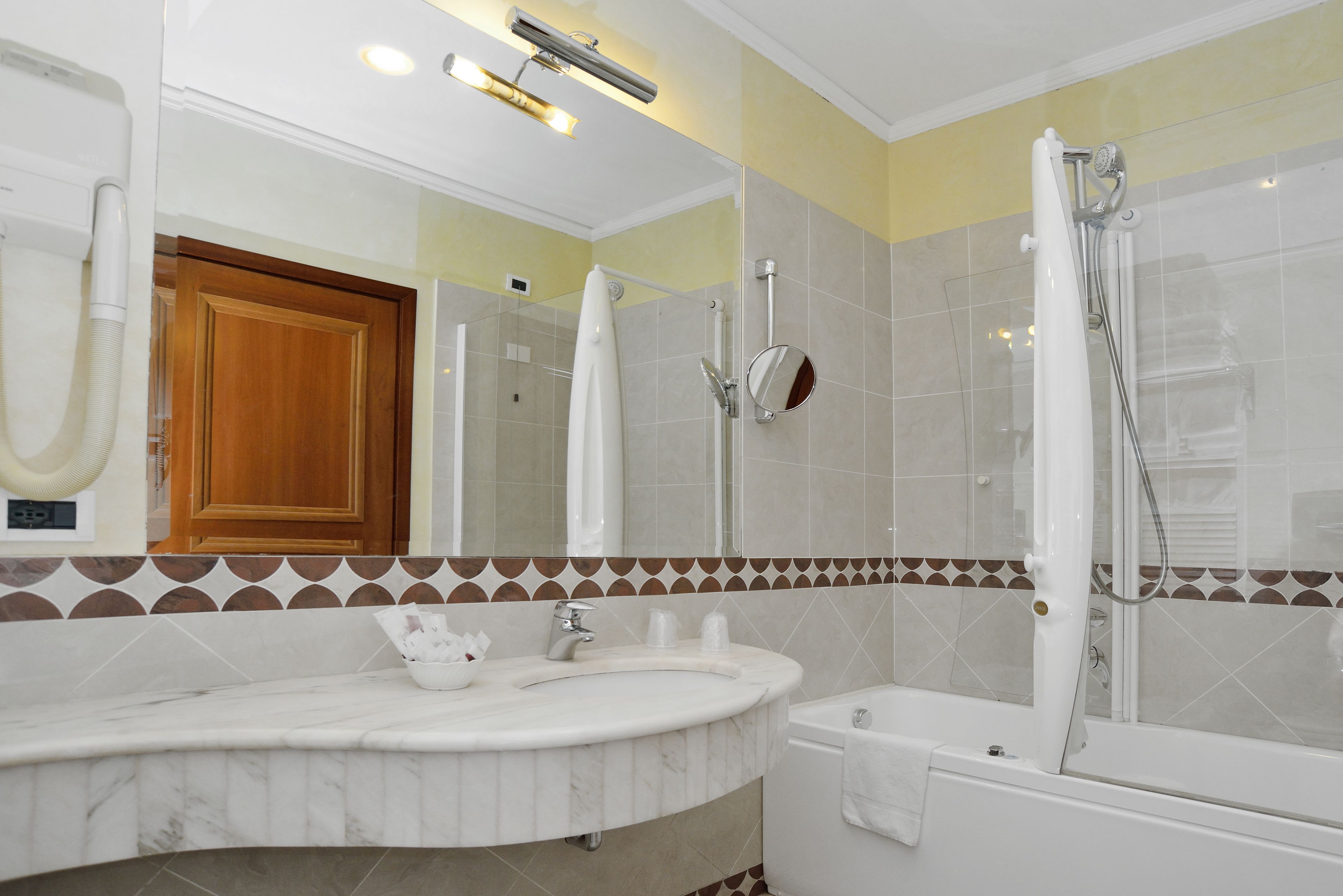 A bathroom with a marble sink, a bathtub, and a shower.