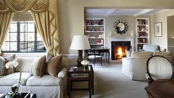 A cozy living room with a fireplace, comfortable seating, and a bookshelf.