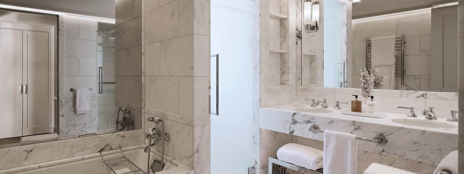 A bathroom with a bathtub, a shower, a large mirror, and a vanity with a sink.