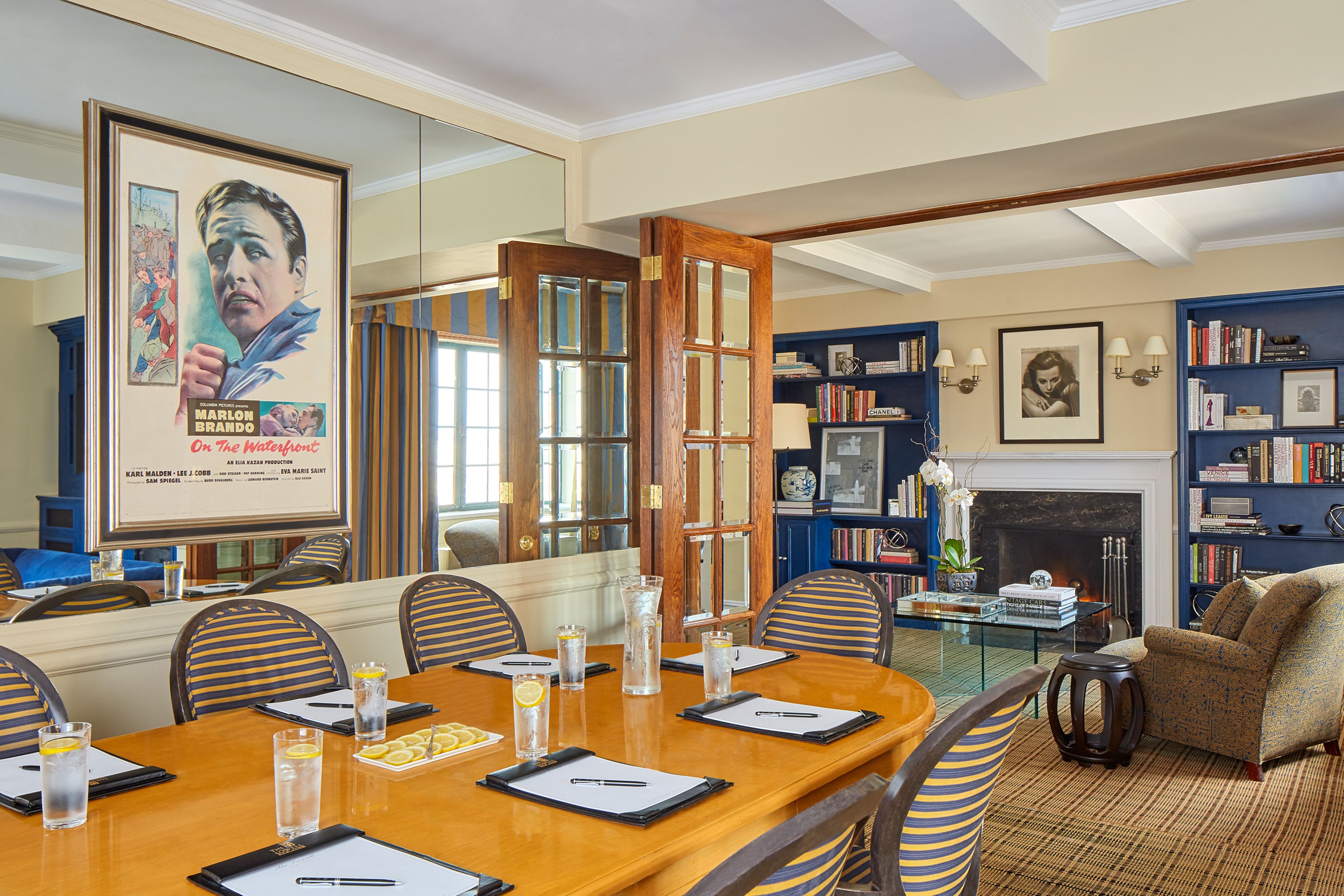 A conference room with a wooden table, chairs, and a fireplace.