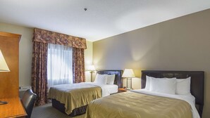 A hotel room with two beds, a desk, and a chair. - Quality Inn Fresno Yosemite Airport (Fresno)
