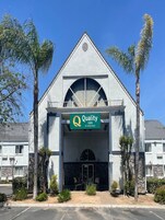 Un hotel de diseño moderno, con un llamativo letrero de 'Quality Inn'.
