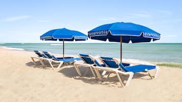 Aan het strand, ligstoelen aan het strand, parasols, strandlakens