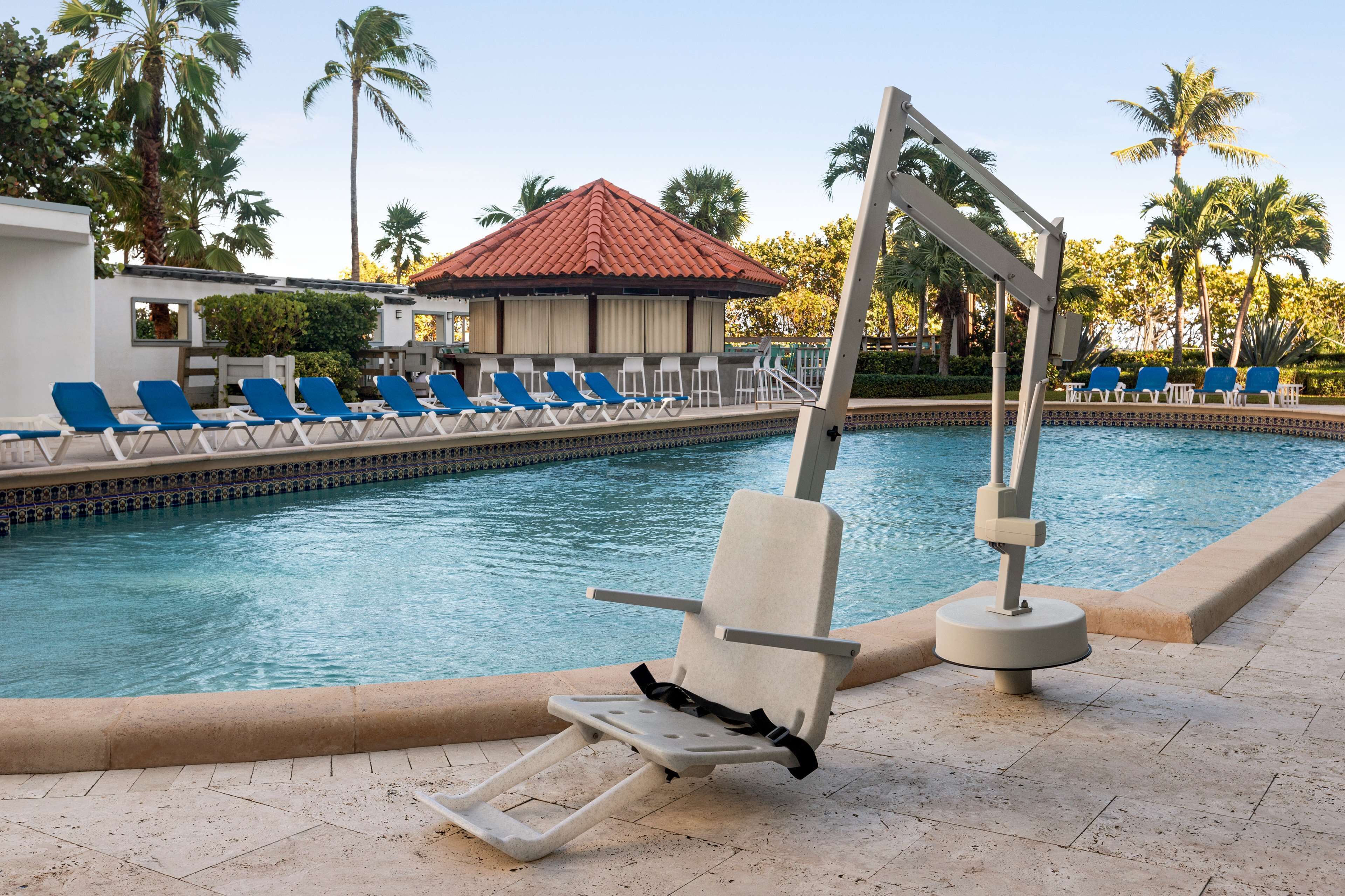 A poolside area with lounge chairs and a lifeguard stand.