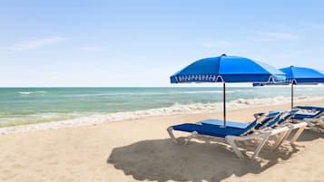 På stranden, solstolar, parasoller och strandhanddukar