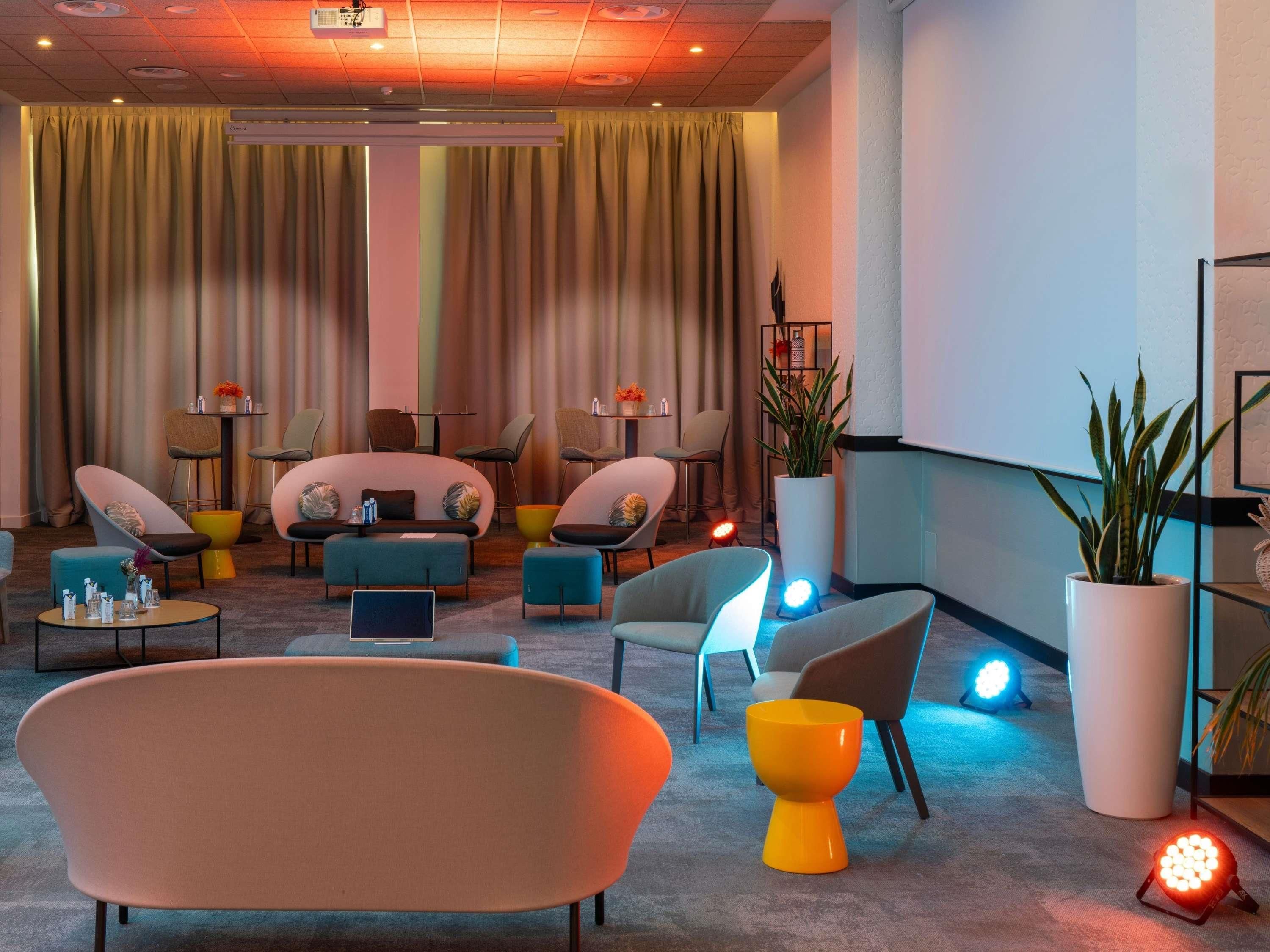 Eine moderne Lounge mit Sofas, Sesseln, einem großen Sessel und einem Tisch mit Annehmlichkeiten.